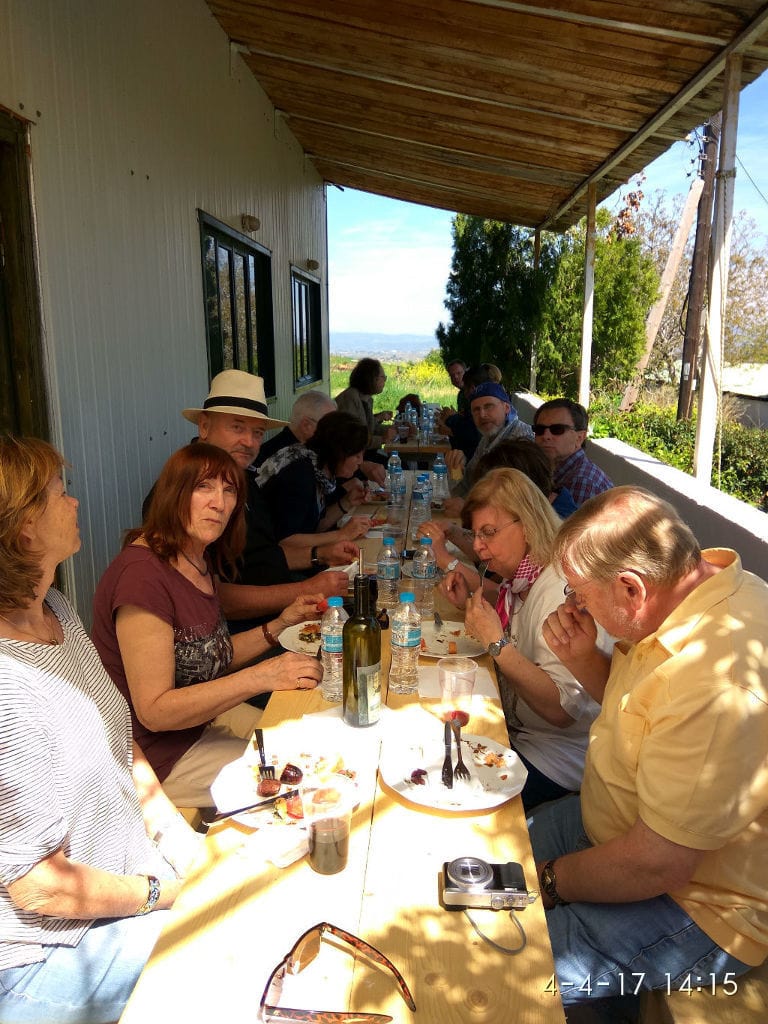 tourists eat at the table at Bio Goupios